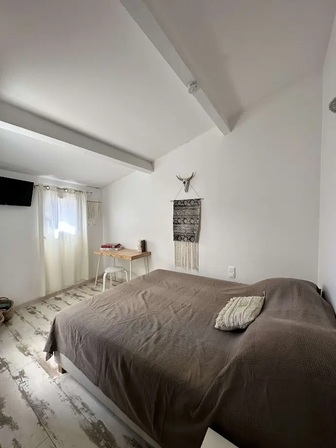 Chambre paisible avec lit double, couverture marron, décor bohème et bureau simple à Loc'Amargue aux Saintes-Maries-de-la-Mer
