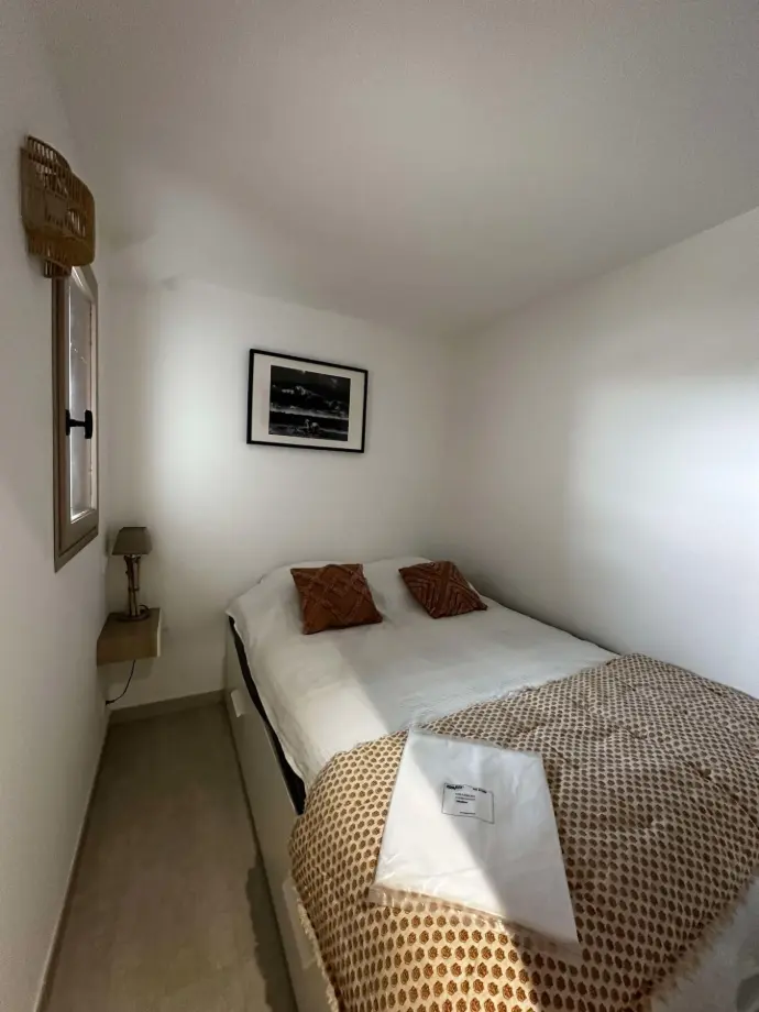 Chambre confortable avec lit double, décoration épurée et éclairage doux.