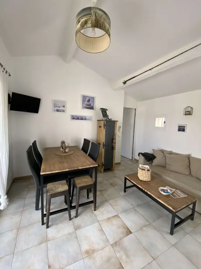 Salle à manger accueillante avec table en bois, chaises assorties et coin salon confortable au Mas des Oliviers, Loc'Amargue, Saintes-Maries-de-la-Mer